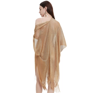 Close-up of golden metallic mesh shawl featuring long fringe detail and sheer texture