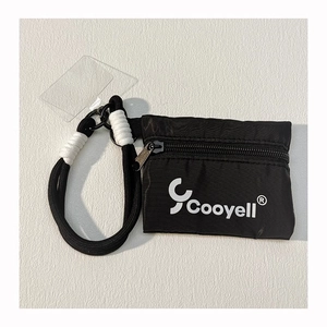 Detail of a black nylon mini pouch with a branded lanyard and white decorative accents