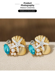Detailed shot of golden shell and silver starfish earrings with blue rhinestones and pearls