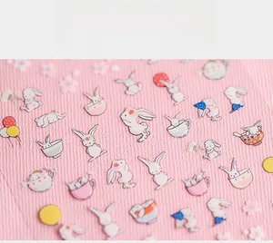 Detailed close-up of 5D embossed cartoon rabbit nail stickers with pink floral patterns