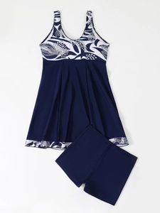 Flat lay of floral tankini set with V-neck top and matching swim shorts in navy blue