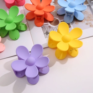 Matte candy-colored floral hair claws in vibrant purple, yellow, and blue finishes