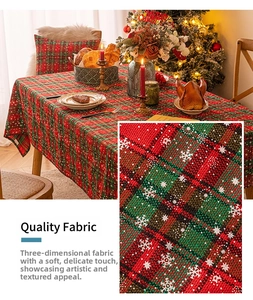 Detailed view of red and green plaid Christmas tablecloth with snowflake print and 3D texture