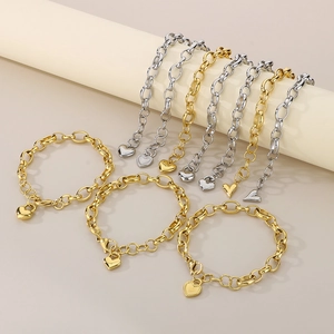 Close-up of heart charm bracelets in gold and silver finish with sturdy link chain design