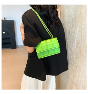 Neon green quilted crossbody bag with gold chain strap shown on black blazer outfit