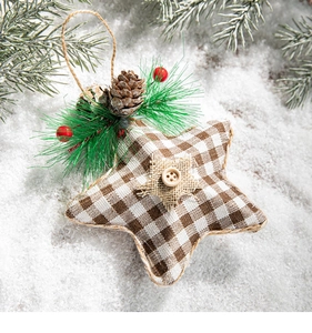 Detail of star Christmas ornament with pine cones and red berries on a snowy background