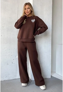 Detail of deep brown sweatshirt with silver heart patch and matching wide-leg sweatpants