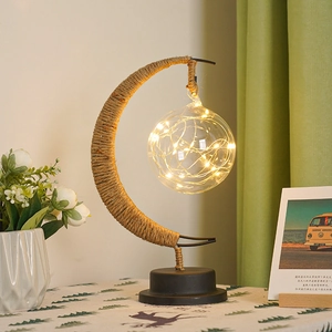 Detail of creative LED moon night light with jute twine iron frame and warm glass globe