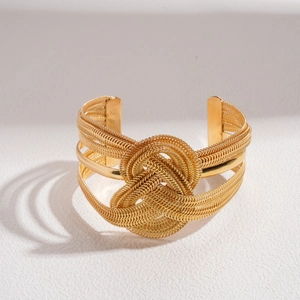 Detail of gold woven open cuff bracelet featuring a large concentric knot design