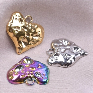 Detailed view of heart-shaped metal charms in gold, silver, and rainbow textured finishes