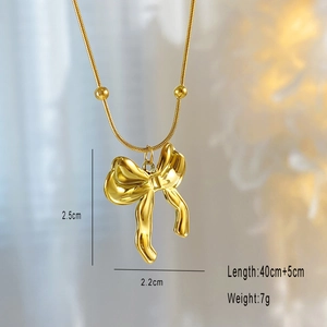Macro shot of gold plated bow pendant necklace showing dimensions 2.5cm by 2.2cm