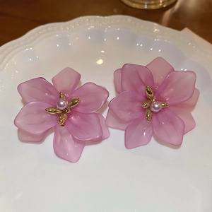 Detail of purple flower petal earrings with pearl center and matte resin texture