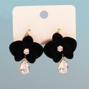Detail of black suede flower earrings with teardrop zircon drop on display card