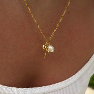 Elegant gold twisted chain necklace with cross, heart, and freshwater pearl charms
