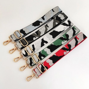 Detail of five adjustable camouflage jacquard bag straps with gold metal hardware