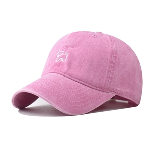Détail d'une casquette en coton lavé rose vintage avec broderie de chien mignonne