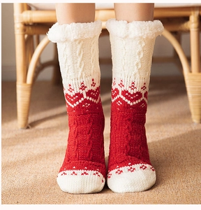 Close-up of red and white knit thermal socks with plush fleece cuffs and heart patterns