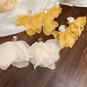 Detail of yellow and ivory chiffon flower earrings with pearls and sparkling crystals