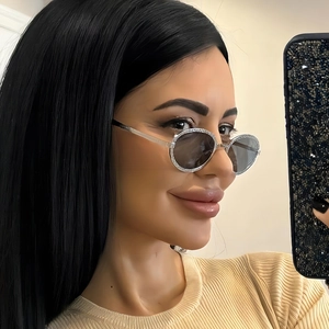 Vintage oval metal sunglasses with silver textured frames and dark lenses on a model