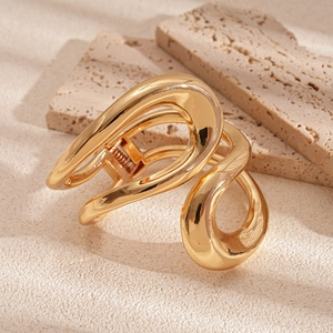Macro shot of gold liquid curve hair claw clip on natural stone background decor