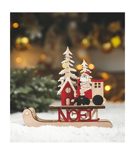 Close-up of a wooden Christmas sleigh ornament with Santa, tree, and NOEL cutout base