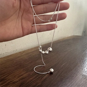Minimalist 925 sterling silver bead necklace with snake chain on a wooden surface