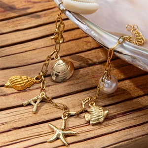 Golden ocean charm bracelet with starfish, seashell, pearl and letter pendant