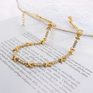 Elegant gold-tone X-shaped necklace featuring sparkling crystals and a French luxury design