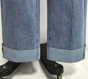 Detail van klassieke blauwe denim jeans met brede omslag en contrasterende dubbele stiksels