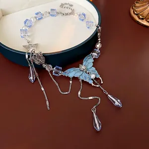 Collier papillon bleu avec glands et perles de cristal sur une boîte à bijoux