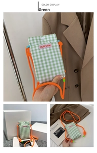 Detail of green checkered mini phone crossbody bag with vibrant orange rope strap