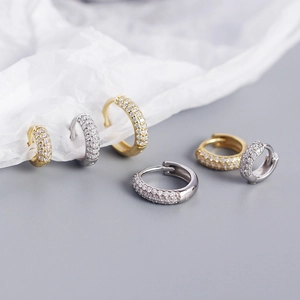 Detailed view of silver and gold plated wide hoops with triple rows of zircon stones