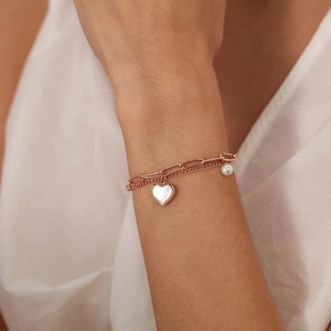 Detail of rose gold double-layer bracelet with heart mother-of-pearl and pearl charms
