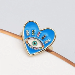 Macro view of gold heart ring with blue evil eye enamel and multicolored zircons