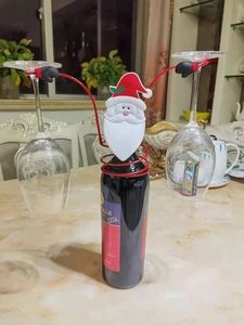 Detailed view of Santa Claus themed red wine bottle holder with two hanging glasses
