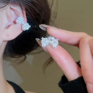 Vue détaillée des clips d'oreilles nœud avec perles et zircons pour oreilles non percées