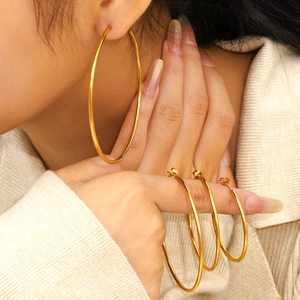 Minimalist large golden metal hoop earrings with high-polish finish for women