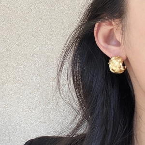 Minimalist gold woven texture C-shaped hoop earrings on model with elegant design