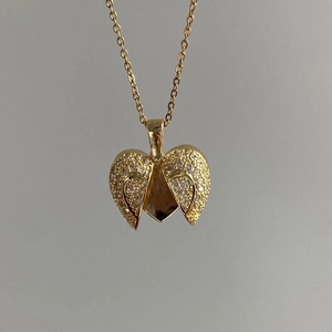 Golden heart wing pendant necklace with pavé crystal accents on a fine link chain