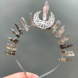 Detailed view of silver crescent moon decor and raw crystal stones on handmade headband