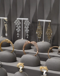 Detailed arrangement of grey velvet bracelet stand and T-shaped earring rack on display