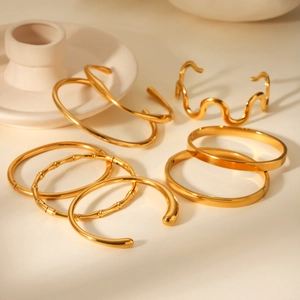 Macro shot of 18K gold plated stainless steel bangles with diverse textured finishes