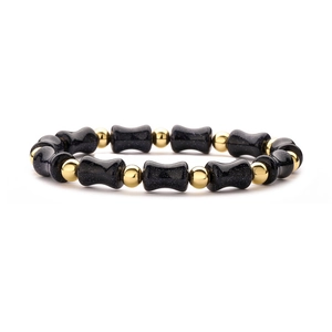 Detailed shot of dark blue goldstone bamboo-shaped beads and gold metal spacers on bracelet