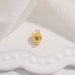 Macro shot of a golden spherical magnetic jewelry clasp for DIY necklaces and bracelets