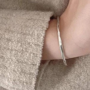 S925 sterling silver cuff bracelet with irregular hammered texture on a woman's wrist