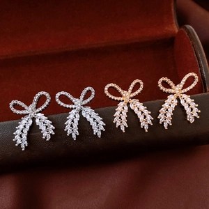 Macro detail of bow-shaped earrings set with sparkling cubic zirconia on a jewelry box