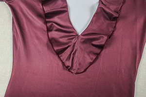 Close-up of deep red satin V-neck dress featuring elegant pleated ruffles and silky texture