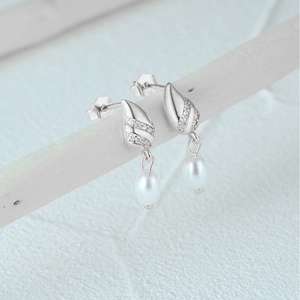Close-up of S925 sterling silver stamp on shimmering leaf-shaped pearl earrings