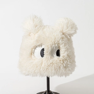Close-up of white plush monster bucket hat with big eyes on a display stand
