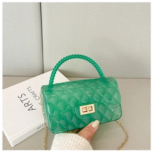 Detail of green transparent jelly bag with quilted pattern and beaded handle strap